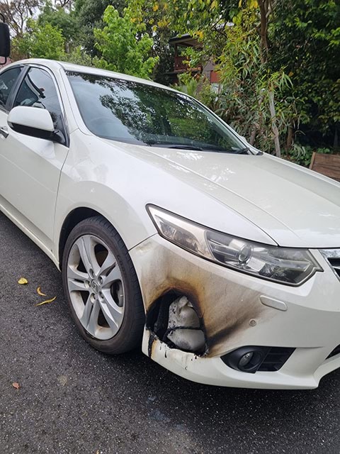 Parked car with burnt front corner panel