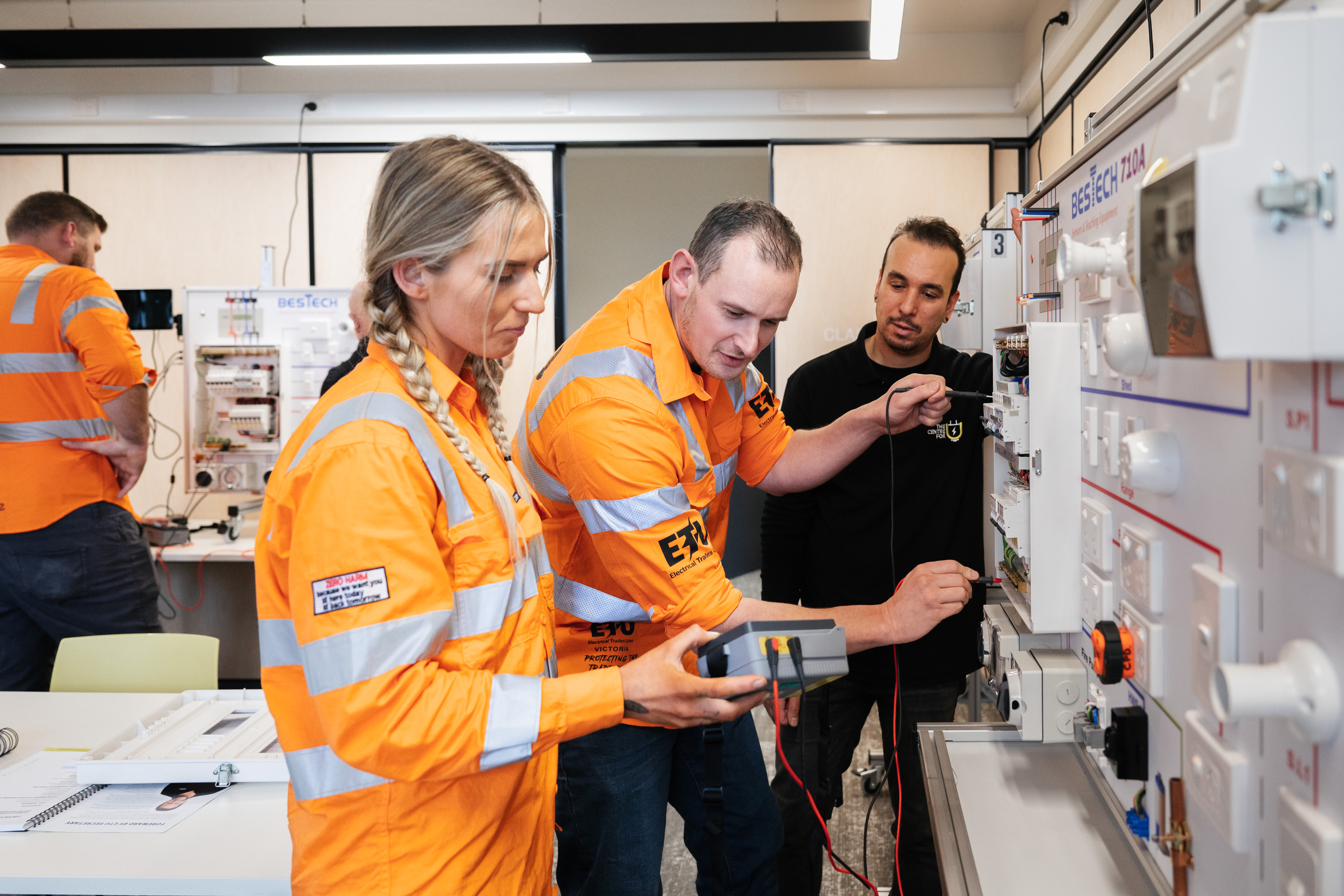 Electrical workers looking at monitoring equipment.