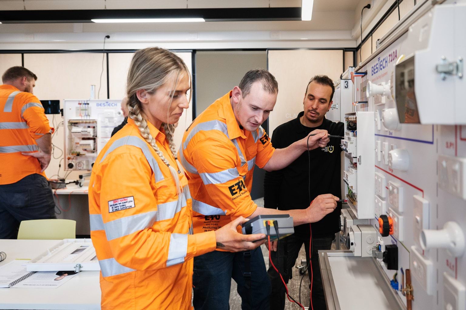 Electrical workers looking at monitoring equipment.